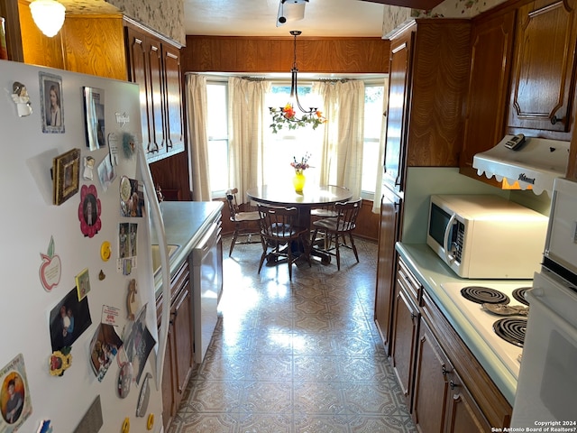 kitchen featuring appliances with stainless steel finishes, hanging light fixtures, a notable chandelier, and light tile flooring