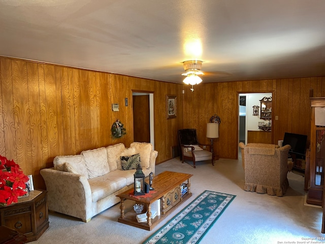 living room with light carpet, wooden walls, and ceiling fan