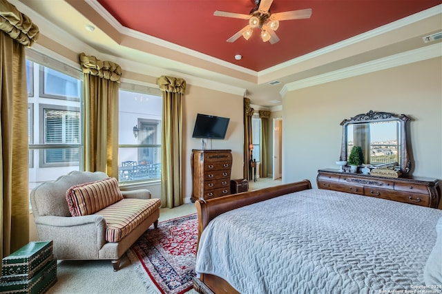 carpeted bedroom featuring ornamental molding, ceiling fan, and a tray ceiling