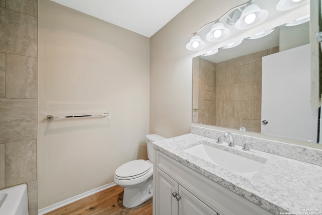 bathroom with oversized vanity, toilet, and hardwood / wood-style flooring