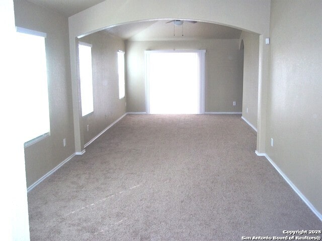 carpeted spare room featuring ceiling fan