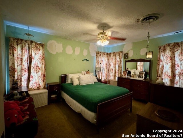 carpeted bedroom with a textured ceiling and ceiling fan