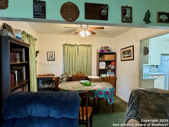 carpeted living room featuring ceiling fan