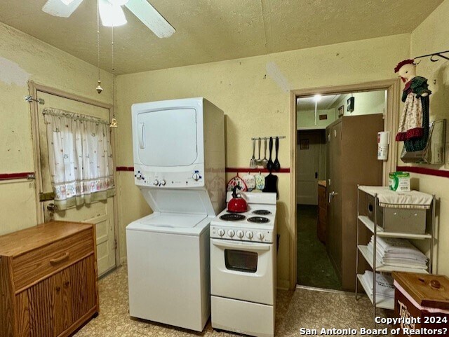 kitchen with white range with electric cooktop, stacked washing maching and dryer, and ceiling fan