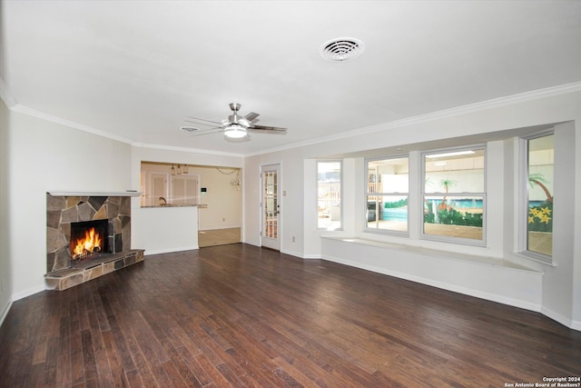 unfurnished living room featuring ceiling fan, crown molding, dark wood-type flooring, and a fireplace