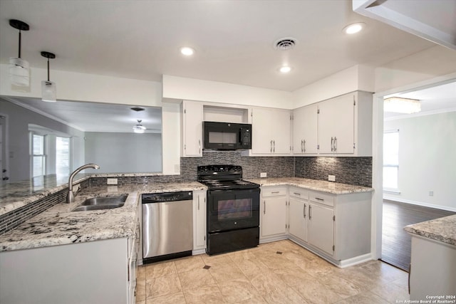 kitchen featuring pendant lighting, backsplash, a wealth of natural light, and black appliances