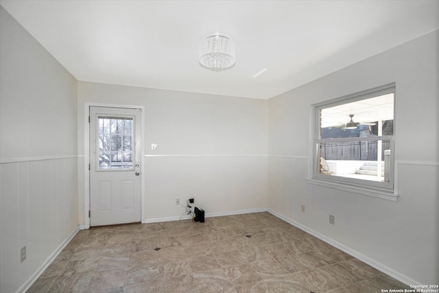 unfurnished room featuring light tile floors and a notable chandelier