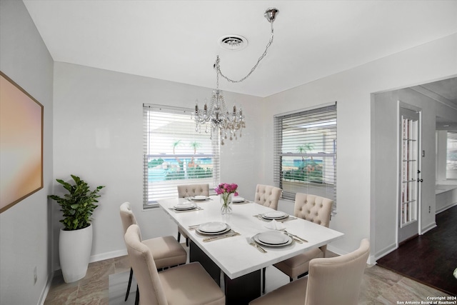 tiled dining space featuring a notable chandelier