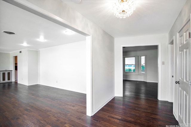 interior space featuring dark hardwood / wood-style flooring, ornamental molding, and a chandelier