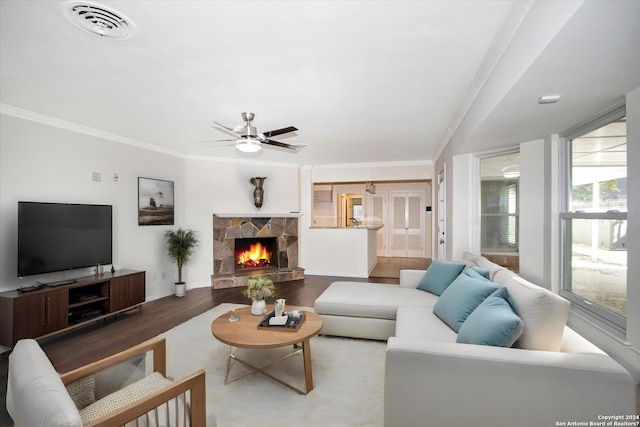 living room featuring ceiling fan, ornamental molding, a fireplace, and hardwood / wood-style floors