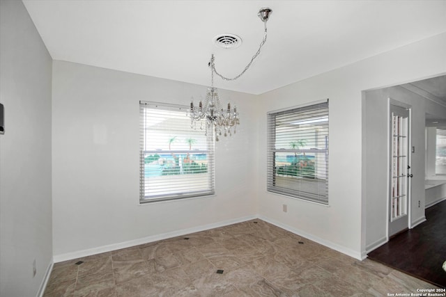 empty room with an inviting chandelier and tile flooring