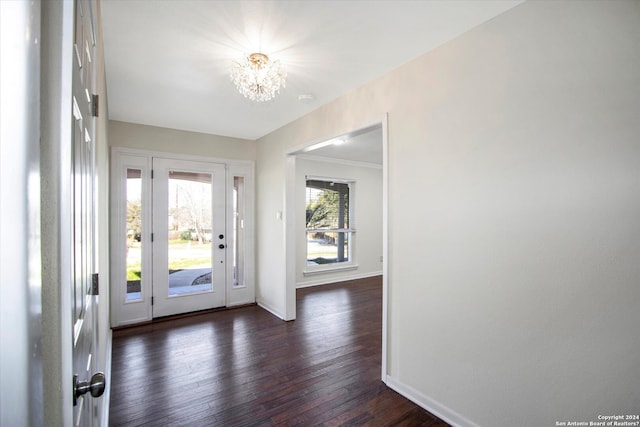 entrance foyer with an inviting chandelier and dark hardwood / wood-style flooring