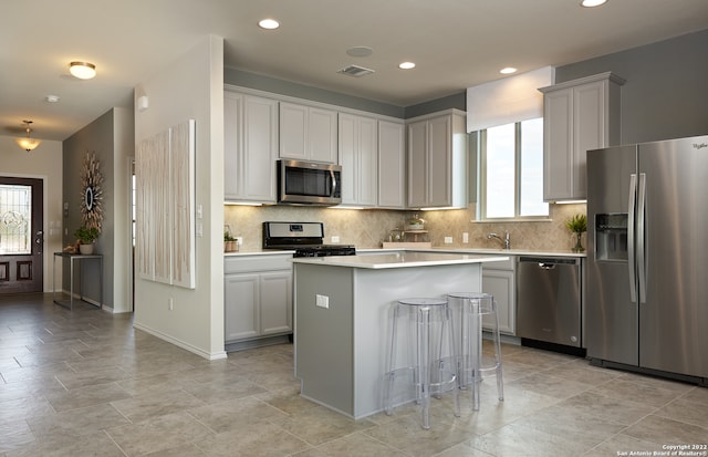 kitchen with plenty of natural light, stainless steel appliances, backsplash, and a center island