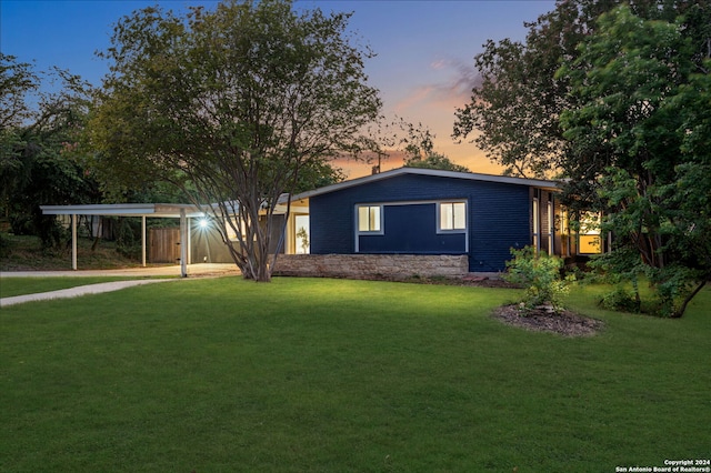 view of front facade featuring a carport and a yard