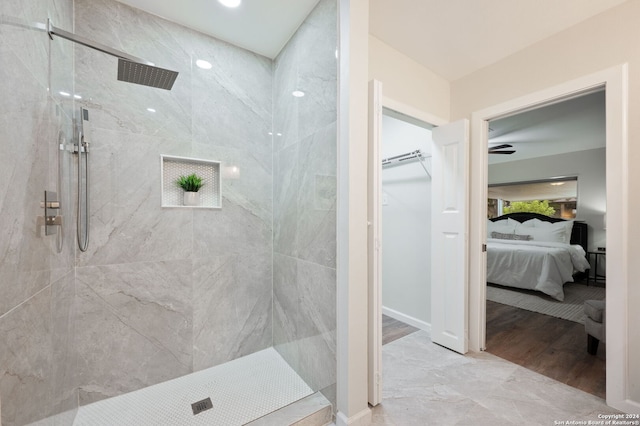 bathroom featuring tiled shower, wood-type flooring, and ceiling fan