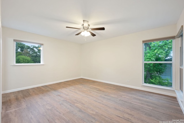 spare room with ceiling fan, hardwood / wood-style flooring, and a wealth of natural light