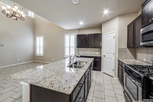 kitchen with an inviting chandelier, tasteful backsplash, sink, and gas range