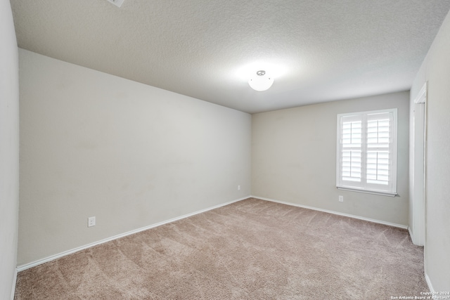 carpeted spare room featuring a textured ceiling