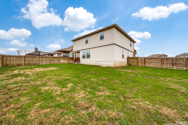 rear view of property with a yard