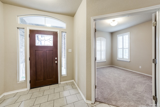 tiled entryway featuring a textured ceiling