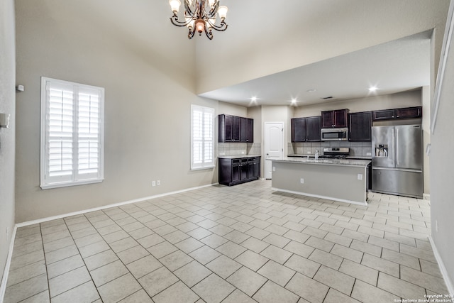 kitchen with light tile flooring, backsplash, appliances with stainless steel finishes, and a wealth of natural light