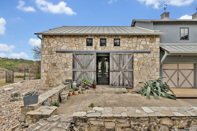 rear view of property with a garage and french doors