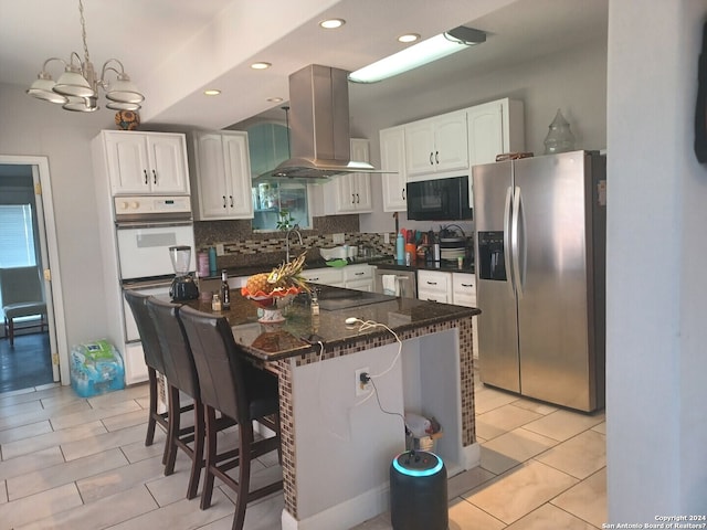 kitchen featuring a chandelier, exhaust hood, a breakfast bar, stainless steel fridge with ice dispenser, and white cabinetry