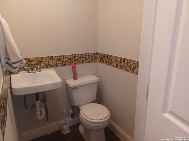 bathroom with toilet, tasteful backsplash, and sink