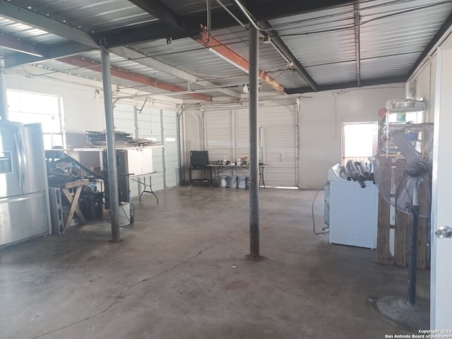 garage featuring stainless steel fridge with ice dispenser