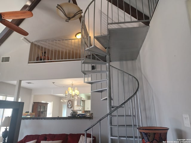 staircase featuring a notable chandelier and a high ceiling