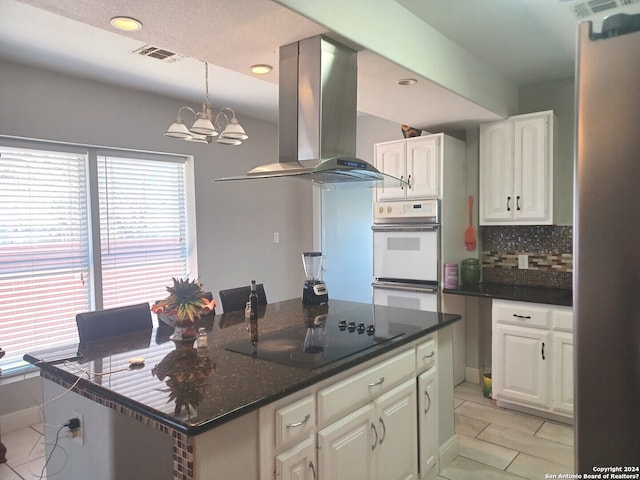 kitchen with ventilation hood, white cabinets, a chandelier, backsplash, and black electric cooktop