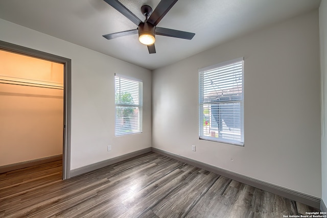 unfurnished bedroom featuring a closet, ceiling fan, and dark wood-type flooring