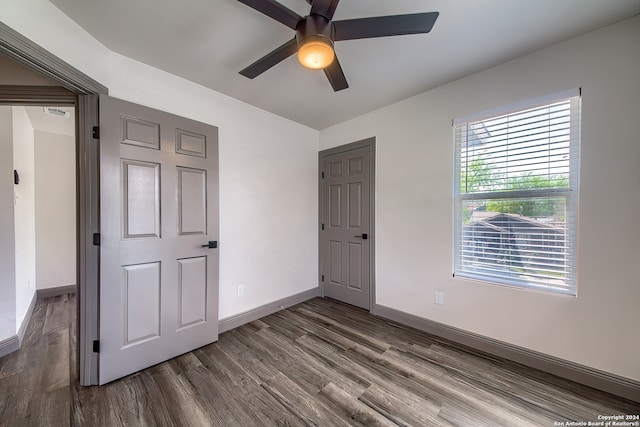 unfurnished bedroom featuring ceiling fan and dark hardwood / wood-style flooring