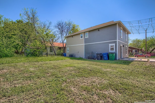 back of house featuring central AC and a yard