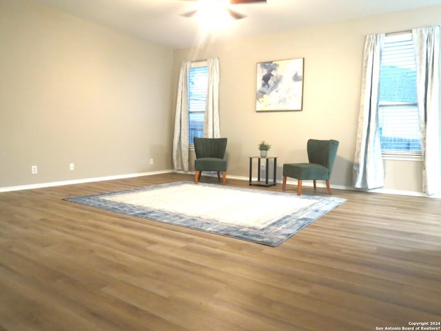 living area featuring ceiling fan and dark hardwood / wood-style floors