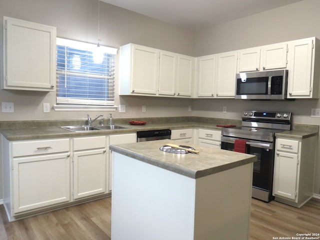 kitchen featuring white cabinetry, appliances with stainless steel finishes, sink, light hardwood / wood-style flooring, and a center island