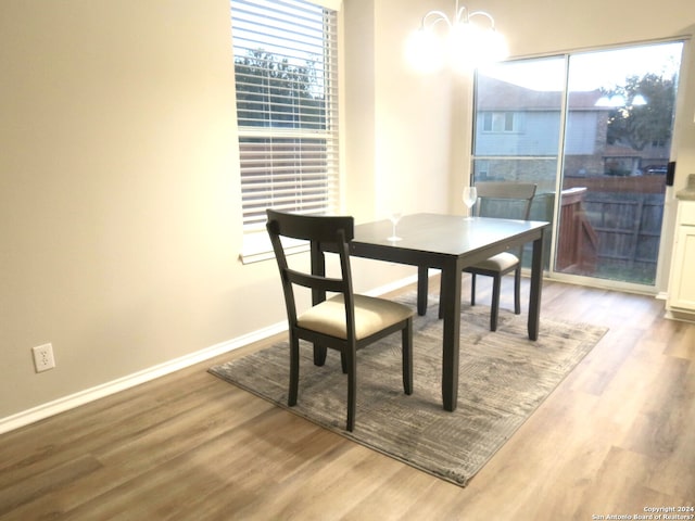 dining area with plenty of natural light, light hardwood / wood-style floors, and a chandelier