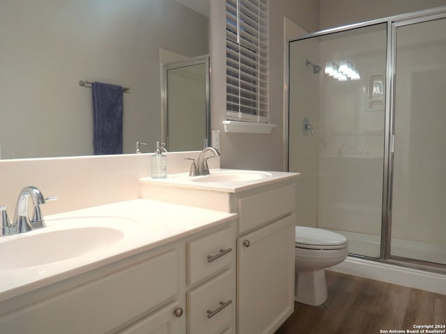 bathroom featuring walk in shower, toilet, vanity, and hardwood / wood-style flooring