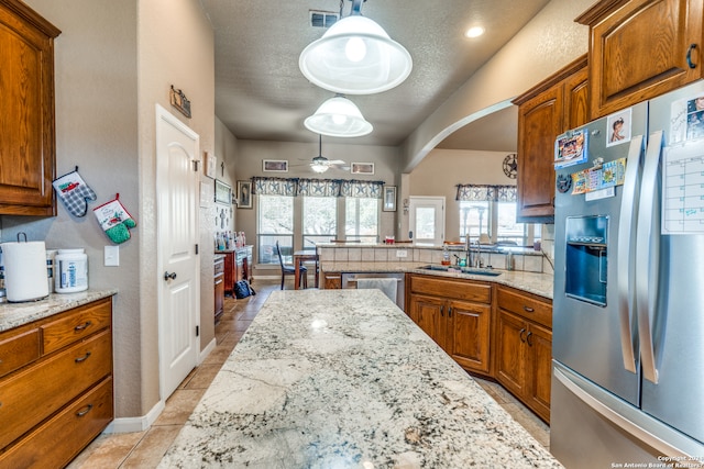 kitchen featuring pendant lighting, ceiling fan, stainless steel appliances, light tile floors, and sink