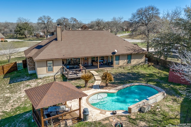 view of swimming pool with a wooden deck, a lawn, and a patio