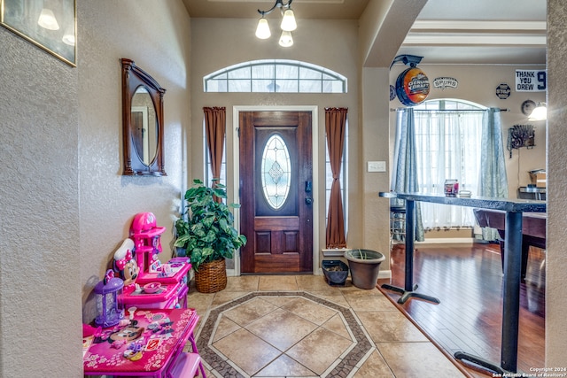 entrance foyer featuring a raised ceiling and light tile floors