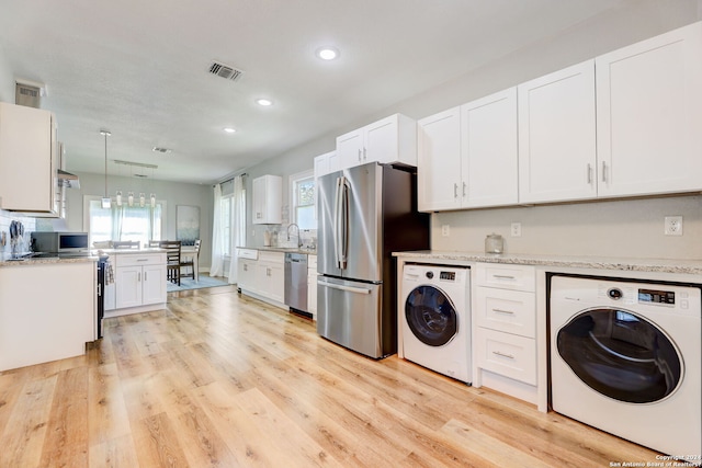 laundry room featuring light hardwood / wood-style flooring, sink, and washer / dryer