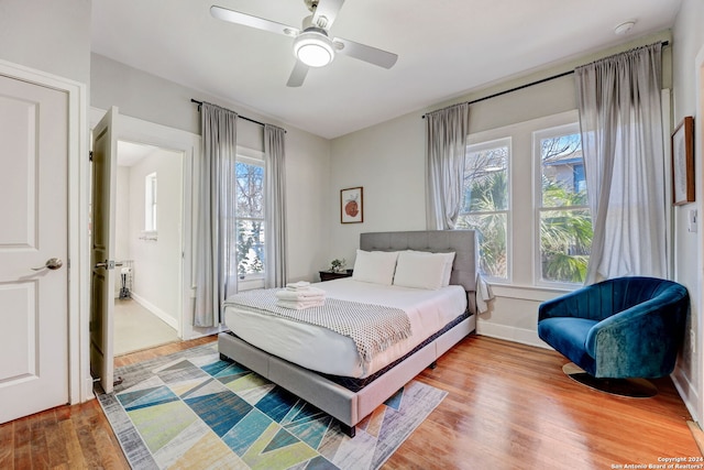 bedroom featuring multiple windows, ceiling fan, and light hardwood / wood-style flooring