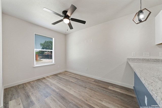 spare room with light wood-type flooring and ceiling fan