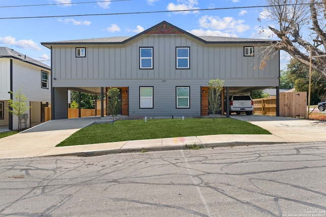 view of front of property featuring a front lawn and a carport