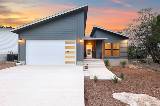 view of front of house featuring central AC unit and a garage