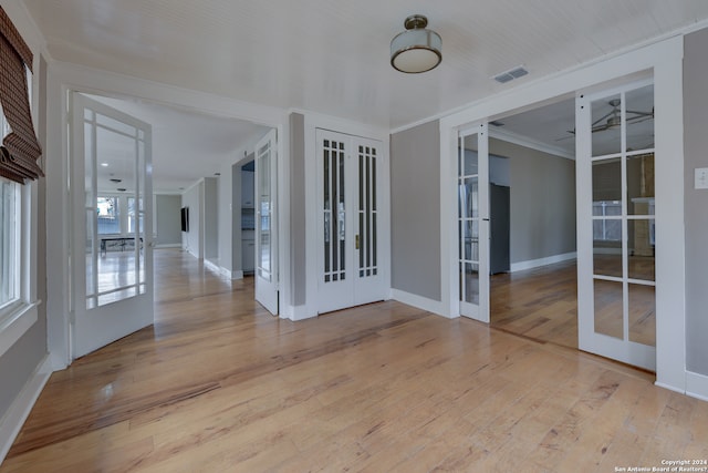 unfurnished room featuring ornamental molding, light hardwood / wood-style flooring, and french doors