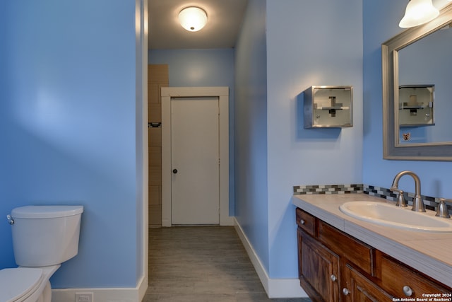 bathroom with hardwood / wood-style floors, toilet, and large vanity