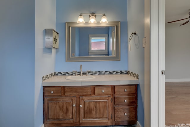 bathroom with hardwood / wood-style floors, ceiling fan, and vanity