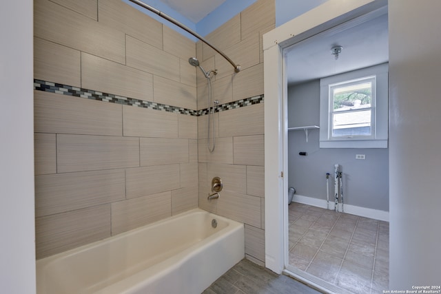 bathroom with tiled shower / bath combo and tile floors